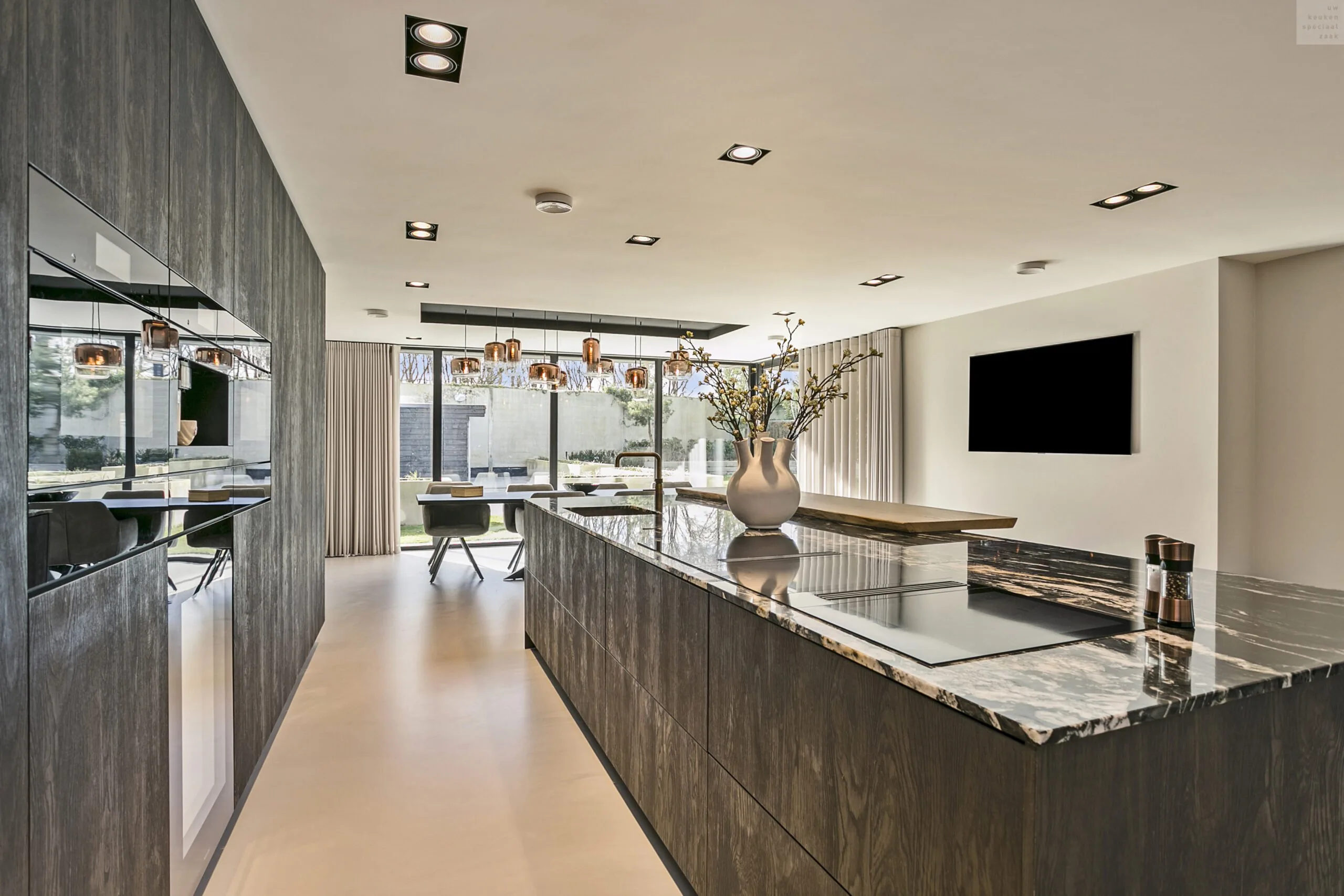 Lang donker houten eiland met marmeren blad en inductiekookplaat